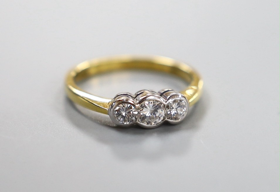 A modern 18ct gold and collet set three stone diamond set ring, size O, gross 3.8 grams